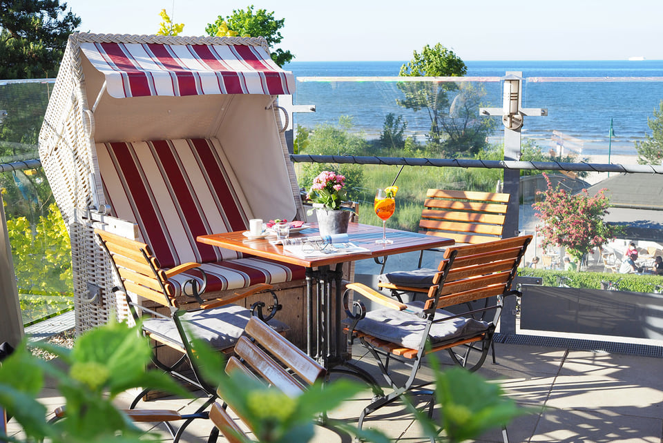 Ein gedeckter Tisch an einem Strandkorb stehend.