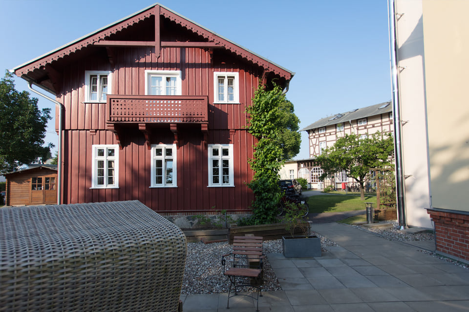 Ein rotes Haus im Innenhof an einem sonnigen Tag